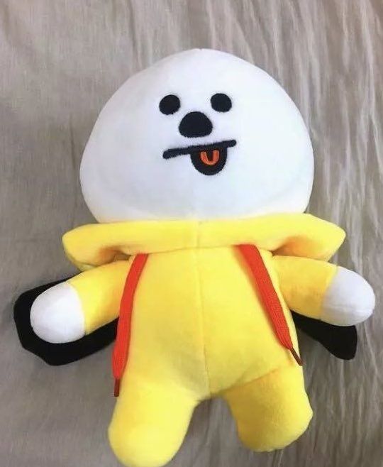 A Line Friends BT21 Chimmy plushie with their hood down showing that Chimmy is naturally bald with no ears. 