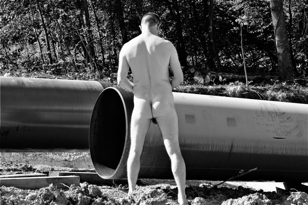 My standing naked in front of a new gas pipeline with my backside facing the camera.