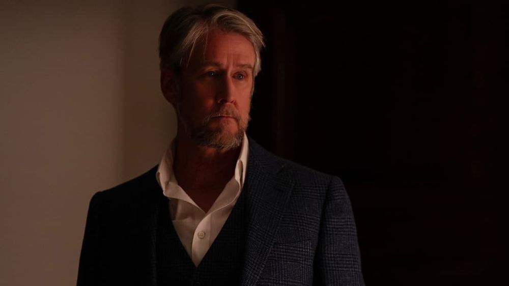 A dramatically lit photo of Alan Ruck playing Connor Roy in Succession, looking off into the middle distance