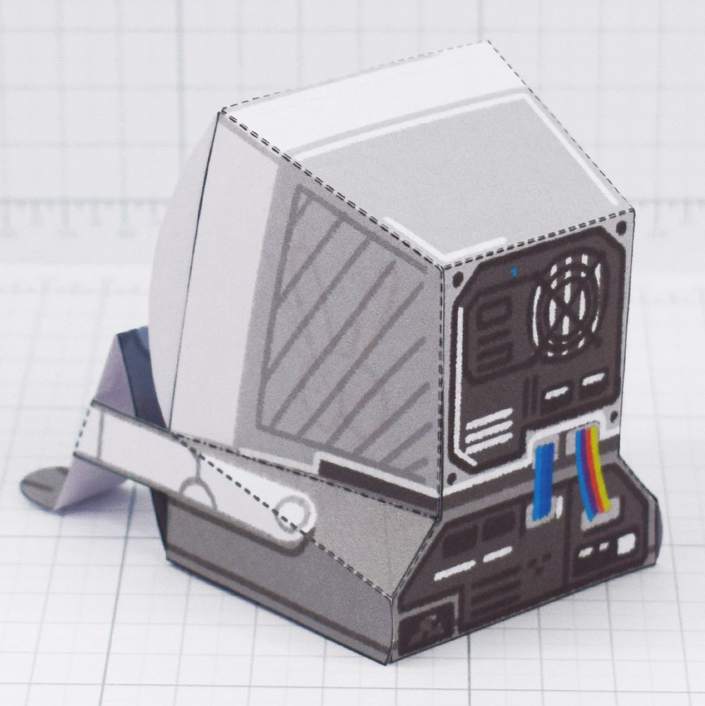 A photo of a papercraft depicting a sad little computer with a blue error face 