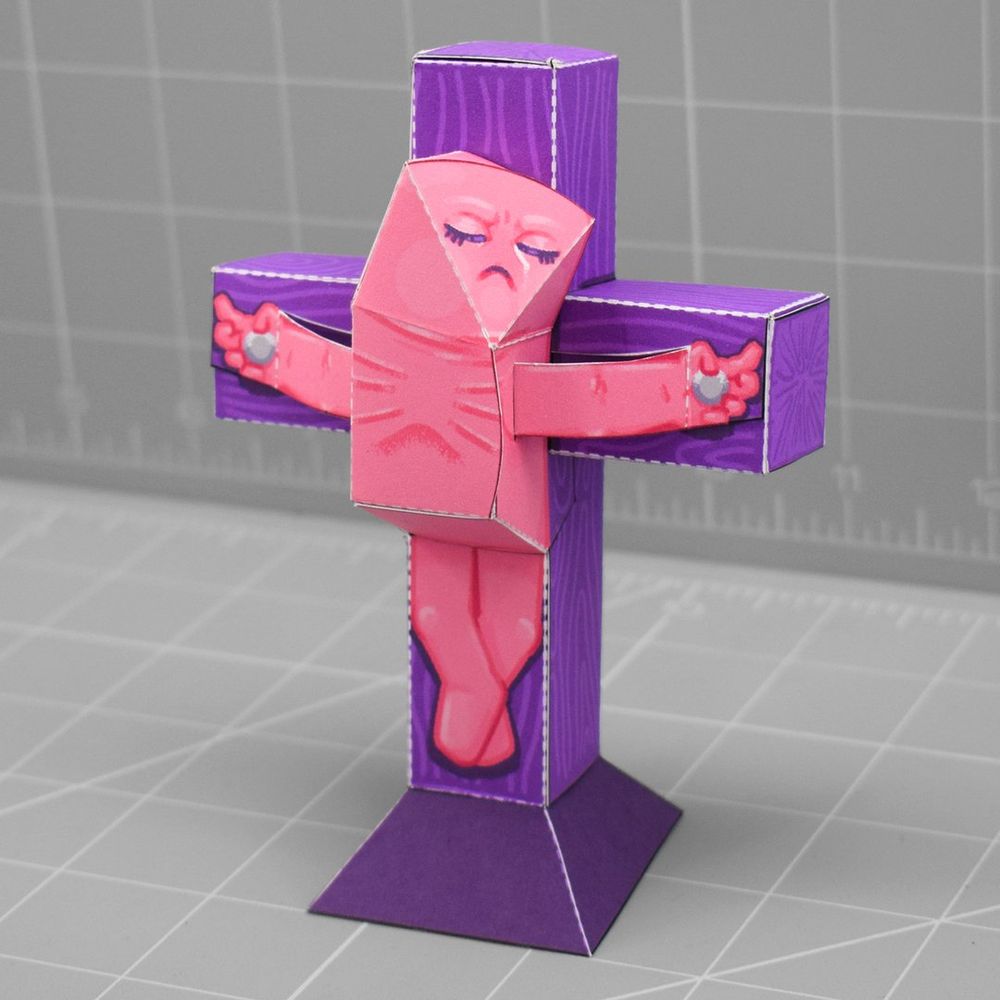 a photo of a papercraft depicting a little pink person being crucified  