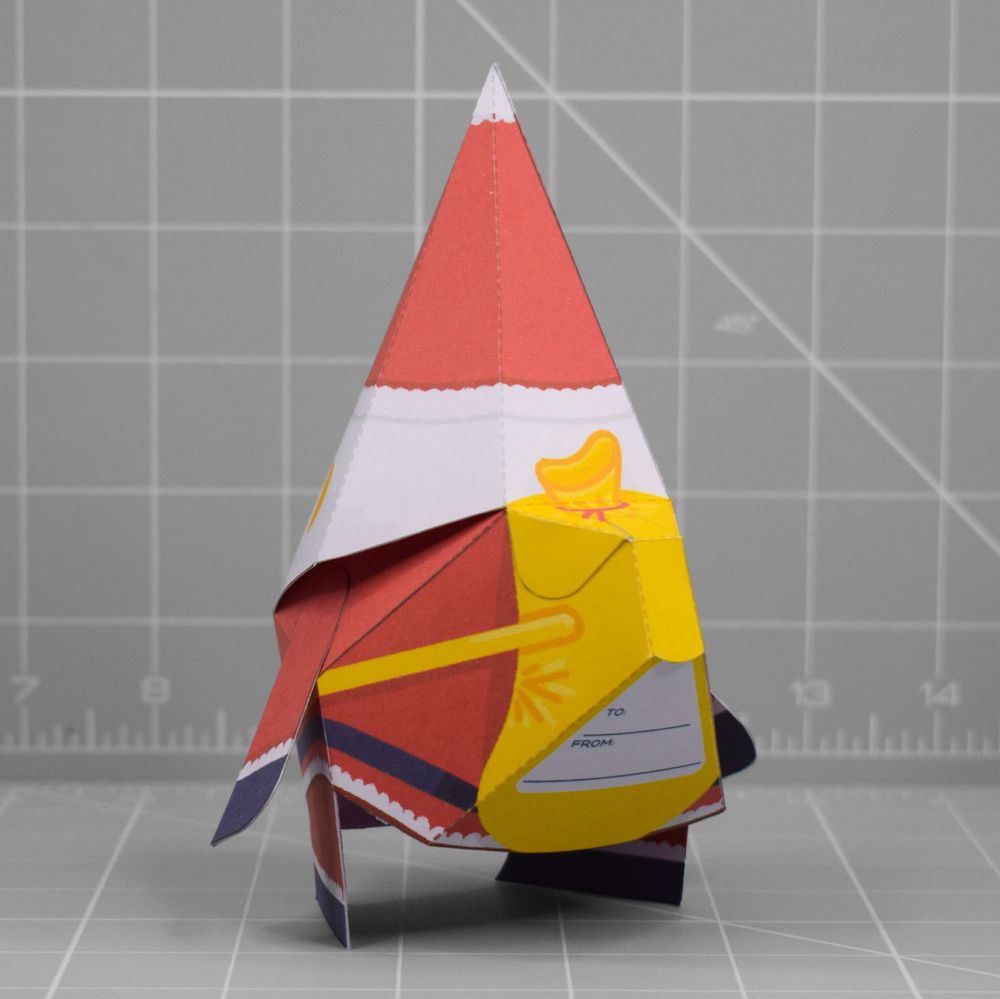 A photo of a papercraft depicting a cheeky looking Santa with yellow skin. 