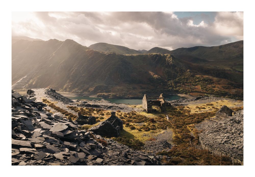 An image of a ruined house in front of mountains 