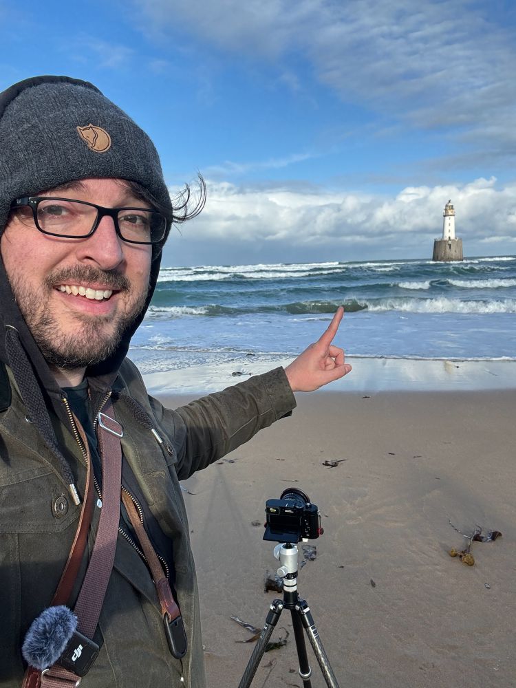 Image of a man pointing at a lighthouse
