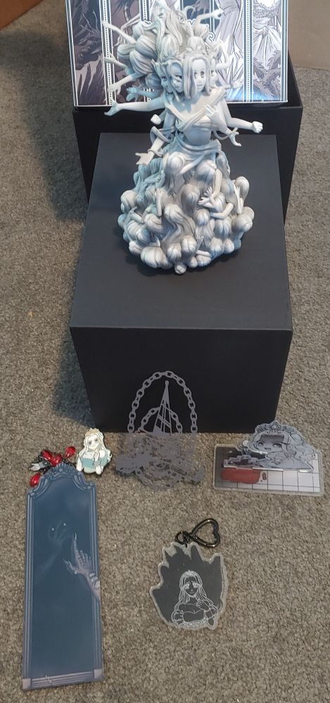 The contents of the Slay The Princess collectors edition, with statue, standee, keychain, pin, etc.