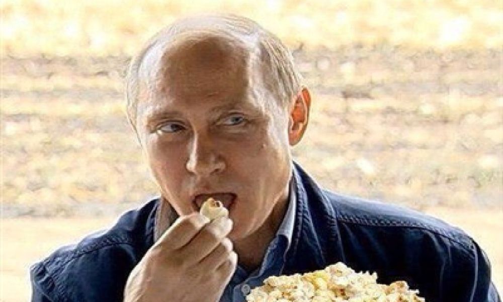Putin eating popcorn watching the US self-destruct from within