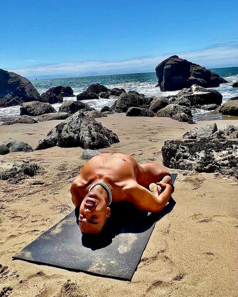 Man practicing yoga on beach