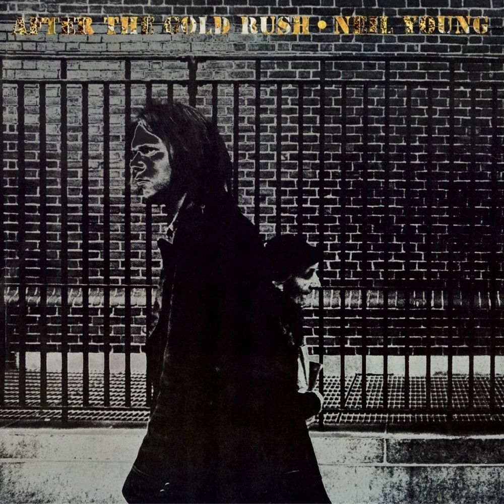 Das Cover von Neil Youngs Album After the Gold Rush auf dem der Künstler und eine ältere Dame im vorbeigehen vor einem Zaun zu sehen sind. Das Bild ist recht düster gehalten. Das Album würde ich als eines von Youngs Meisterwerken bezeichnen