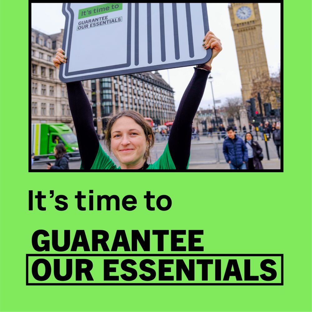 Woman holding up a placard outside Westminster saying it is time to guarantee our essentials 