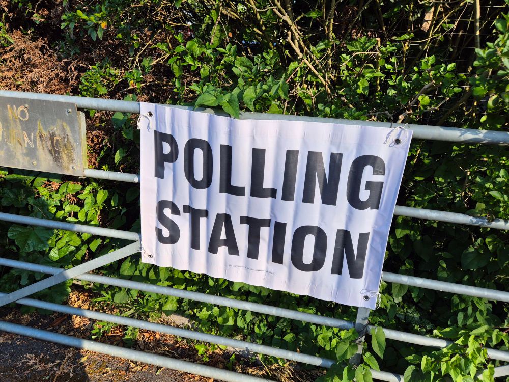 Polling Station sign attached to a metal gate.