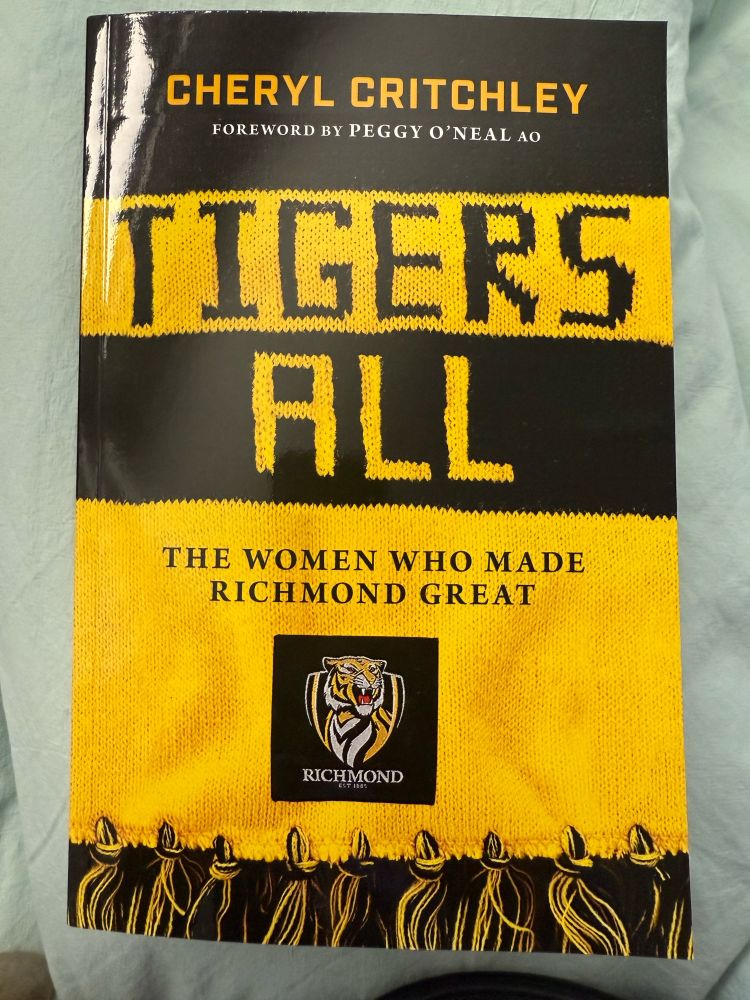 A book about the Richmond Football Club with a Richmond tigers scarf on the cover with the words “Tigers All. The women who made Richmond Great”.
This is written by Cheryl Critchley in conjunction with Peggy O’Neal and gathering the stories of the women who made Richmond great.