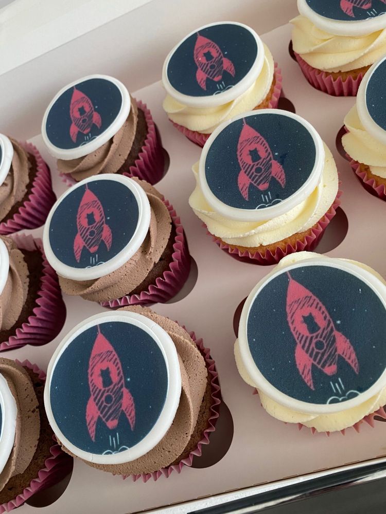 Photograph of cup cakes with pictures of rockets on them which feature on the cover of the book Social Work Cats and Rocket Science an A to Z of rights based practice 