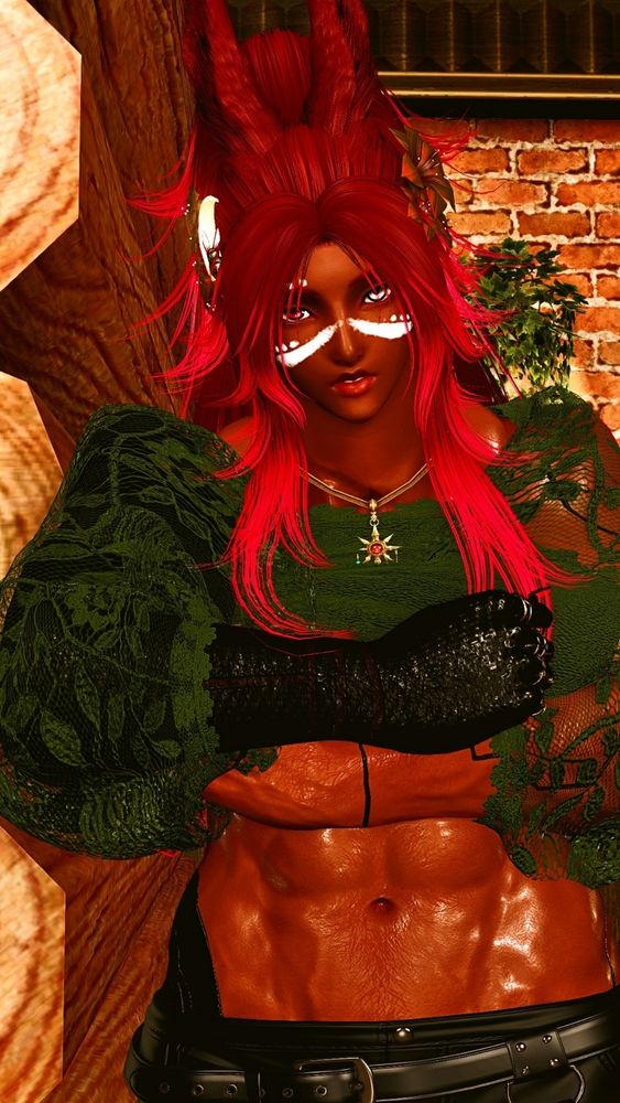 Nicholas is leaning against a wall in his apartment. Wearing a green lace blouse with black pants.