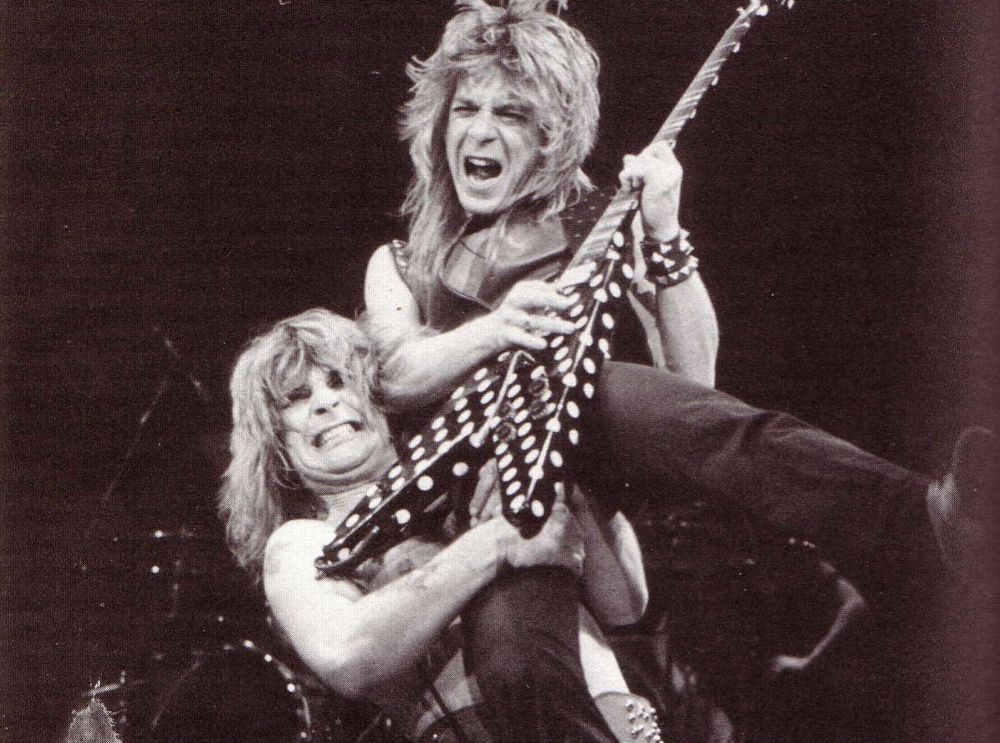 Ozzy Osbourne lifting guitarist Randy Rhoads.
