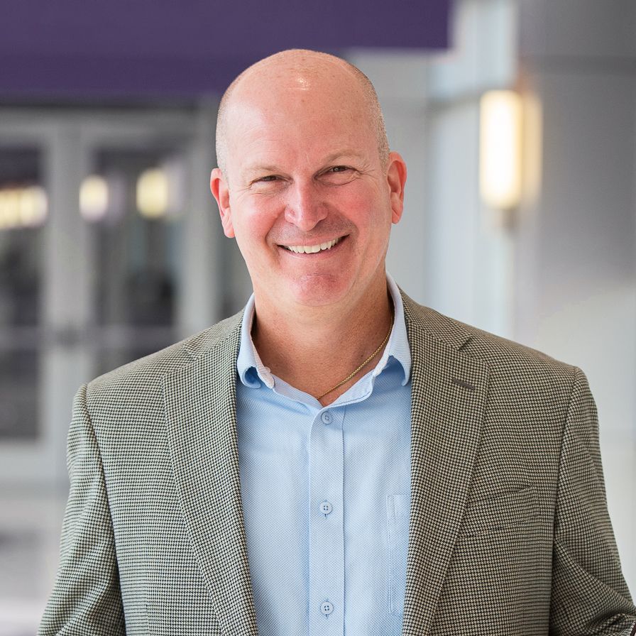 A photo of the new dean of the LSU E.J. Ourso College of Business, Russell Crook, in a blazer and blue shirt.