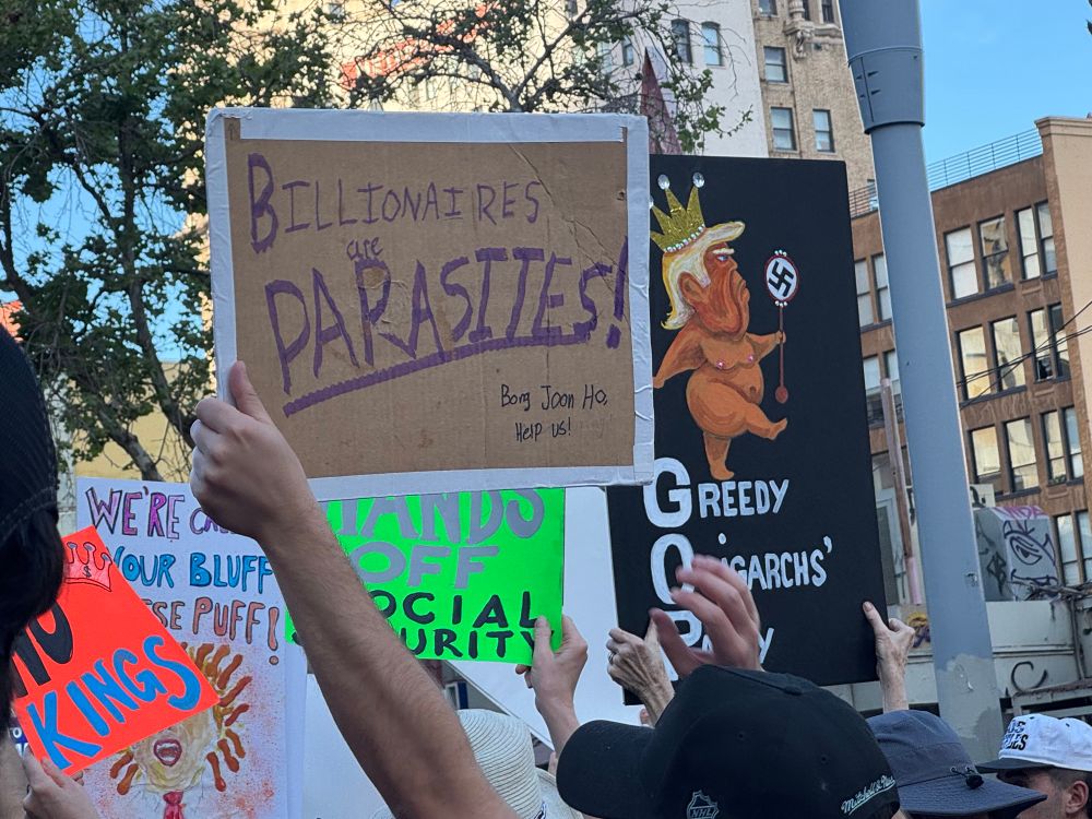 Protest signs 1 ask Bong Joon Ho for help with billionaire parasites