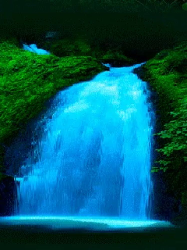 a blue waterfall is surrounded by greenery