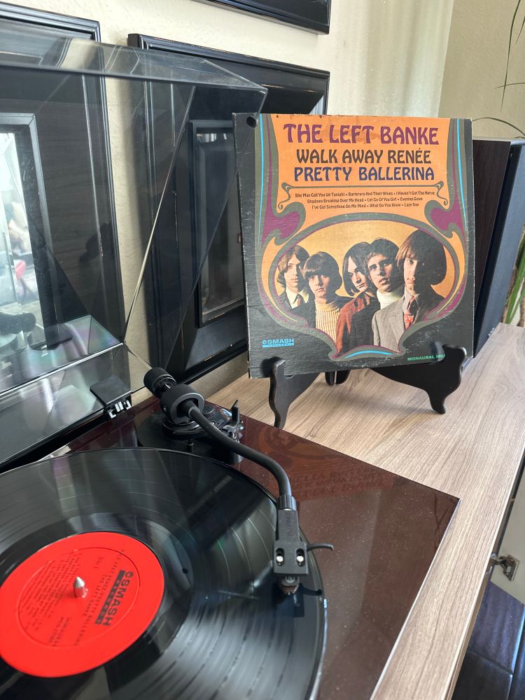 The left banke walk away renee/pretty ballerina black vinyl record on a brown turntable 
