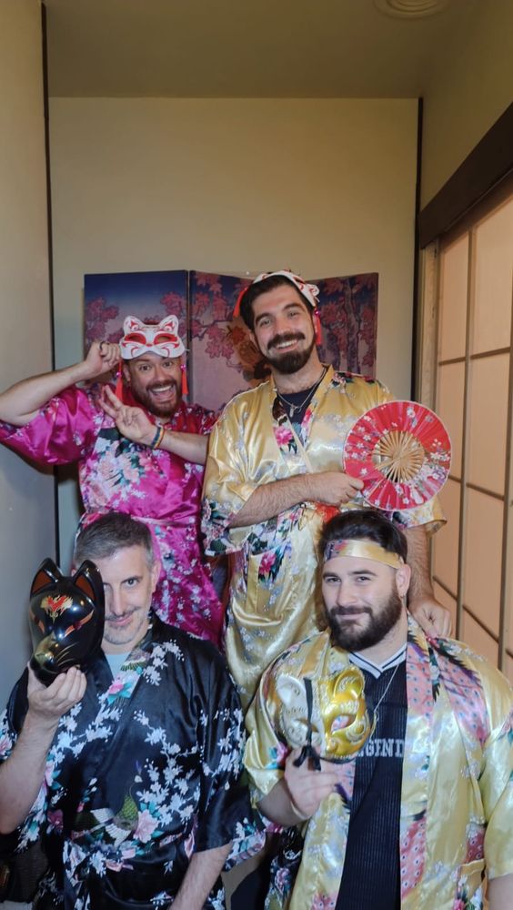 Foto de grupo post escape room, los cuatro con kimonos de flores y máscaras de gato