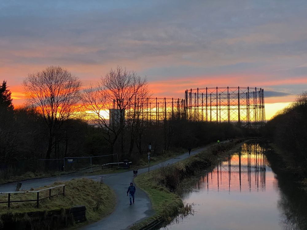 The sun setting behind two Victorian gas holders next to the Forth and Clyde canal in Anniesland, Glasgow.