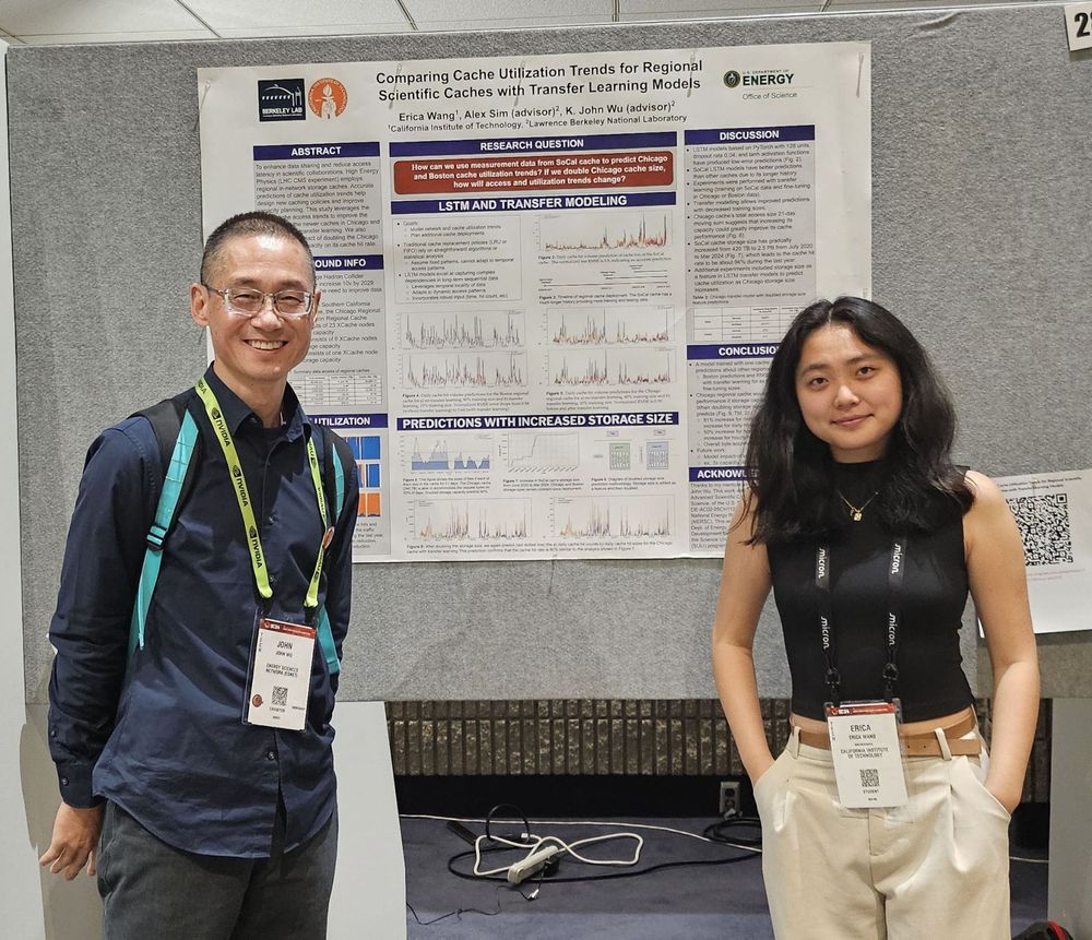 Two researchers pose with a scientific poster
