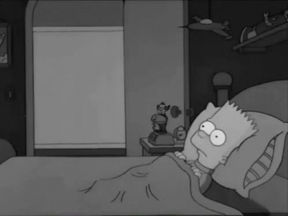 bart simpson is laying in bed with a pillow and a blanket .