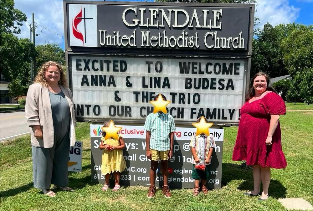 New members stand in front of the outdoor marquee sign with their foster kids at Glendale United Methodist Church in Nashville, TN.