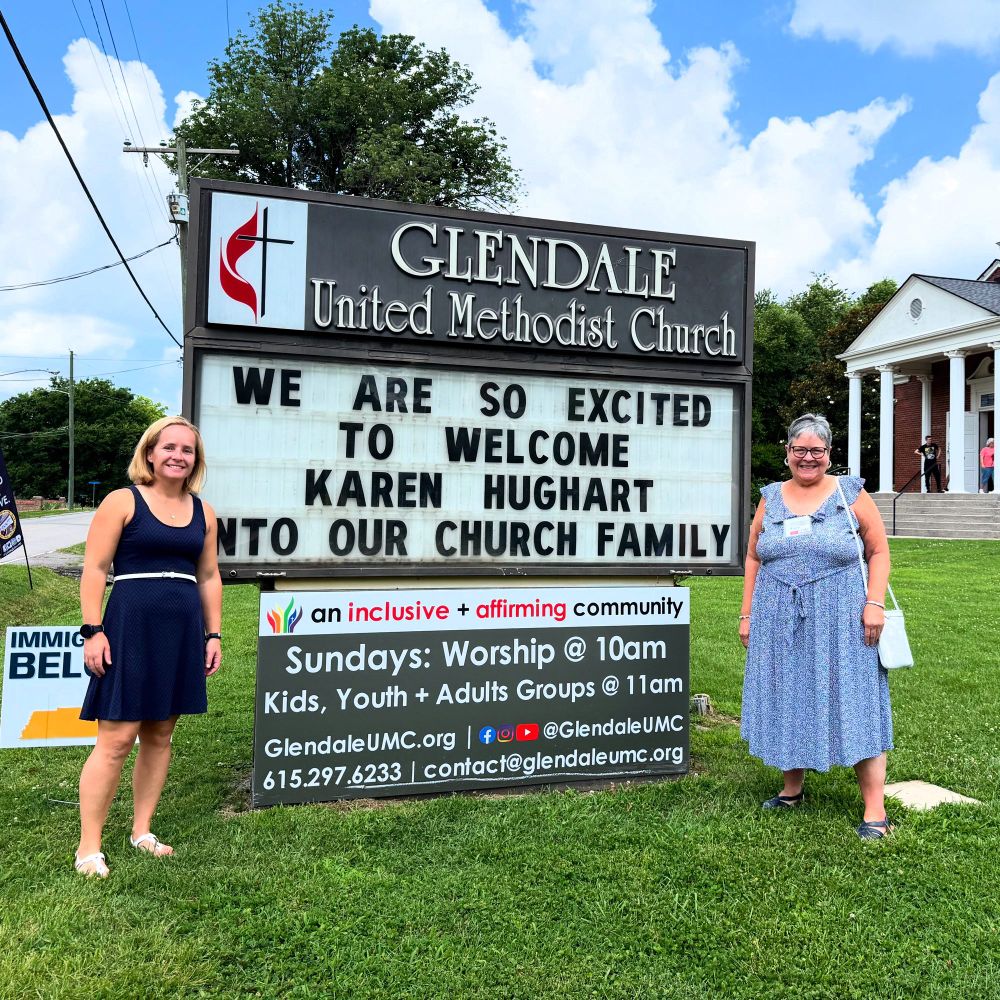 Pastor Steph Dodge and new member Karen Hughart stand beside the outdoor sign with a message welcoming Karen into our church family after she joined in worship. 