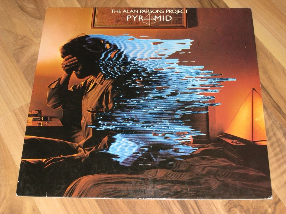 Plattencover von „Pyramids“ von The Alan Parsons Project aus dem Jahr 1978.

Mann sitzt auf Bett. Fotografiert von der Seite. Hält sich eine Hand vor die Augen. Sein Körper digital verfremdet.