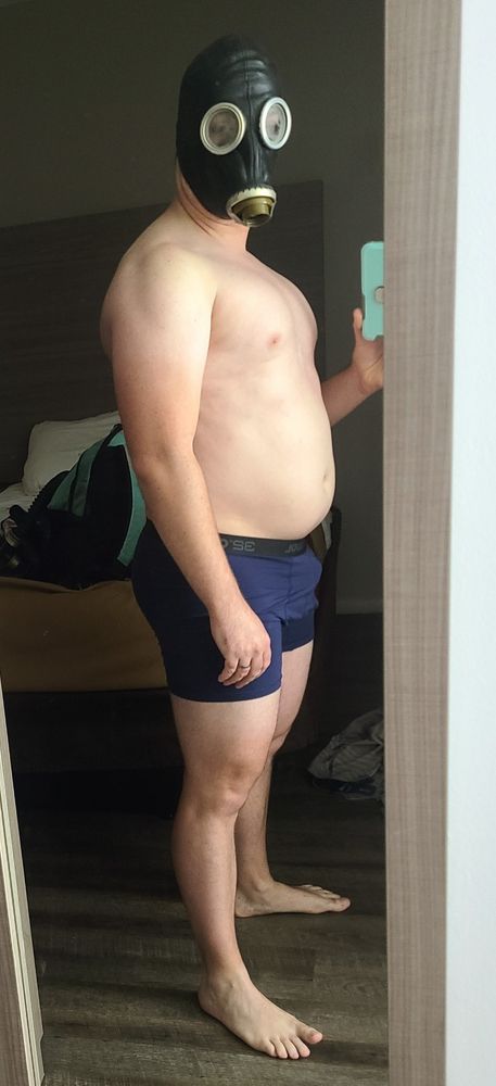 A full-body shot of El Dad in underwear and a gas mask