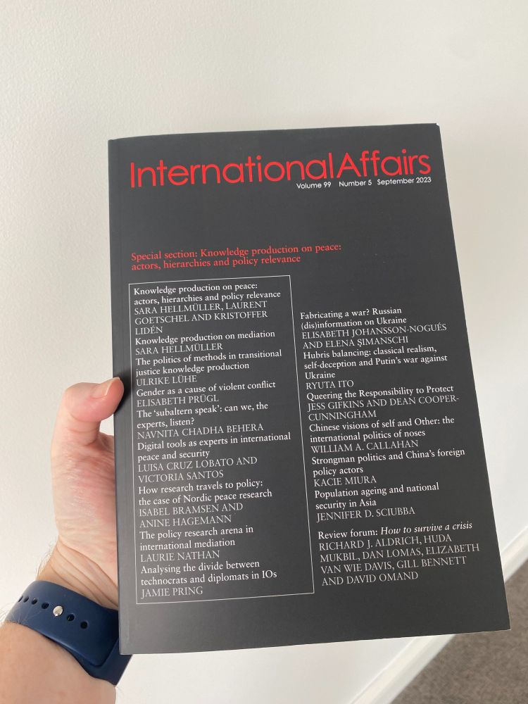 Hand holding a hard copy of the journal International Affairs.