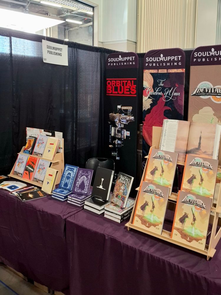 SoulMuppet stand at GenCon 2025 with various ttrpg books on stands