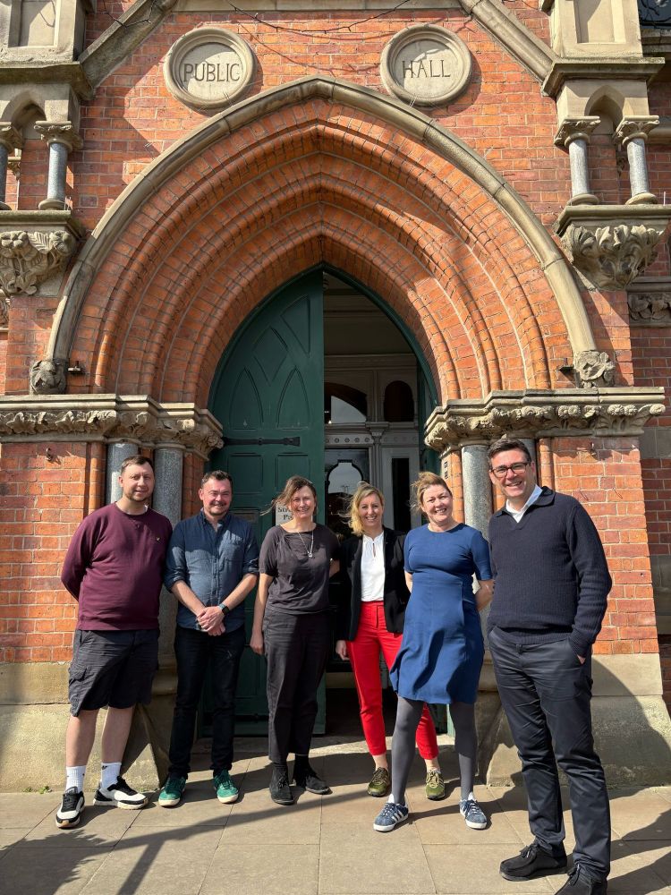 Andy Burnham, Annoushka Deighton, Tony Armstrong, Kate McGeevor and others pose outside Stretford Public Hall