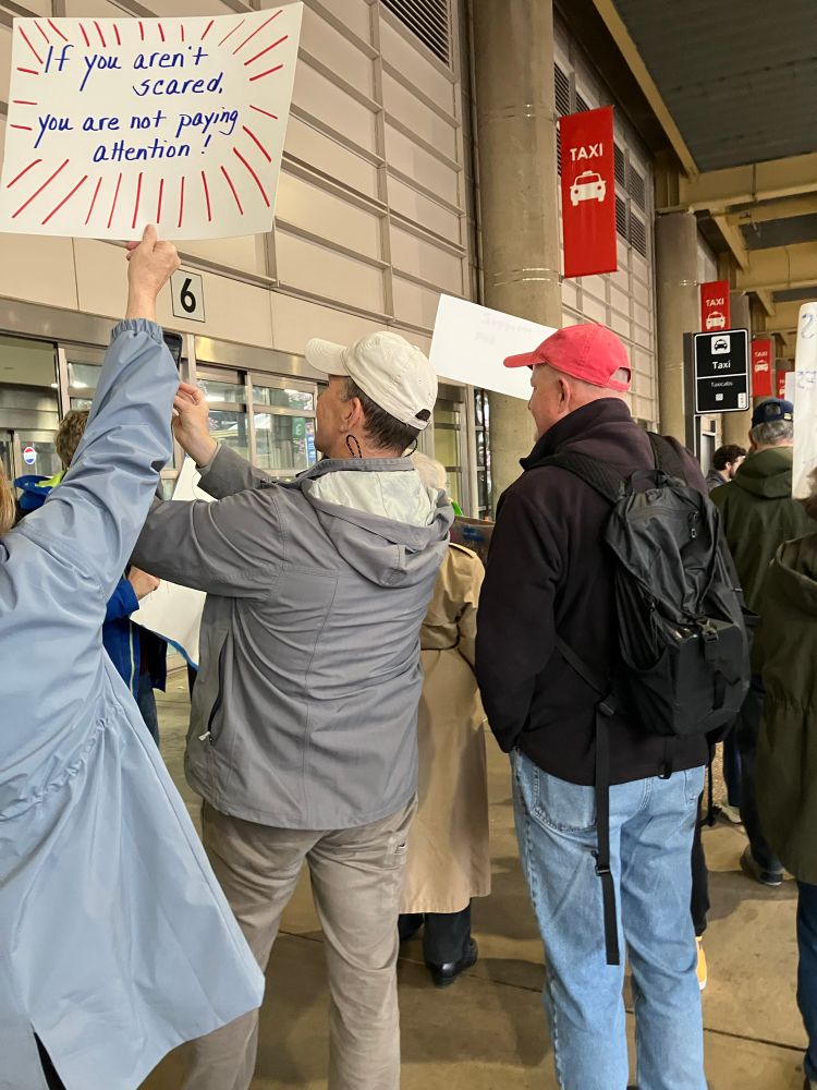 Demonstrators with signs outside Arrivals