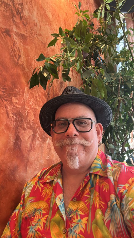 Picture of an incredibly handsome moustached gentleman with a Hawaiian shirt. 
