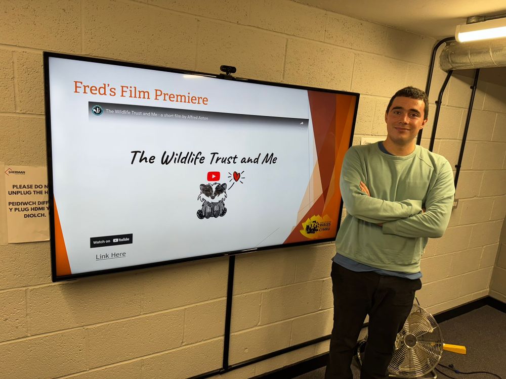 Fred stood next to a screen showing his film.