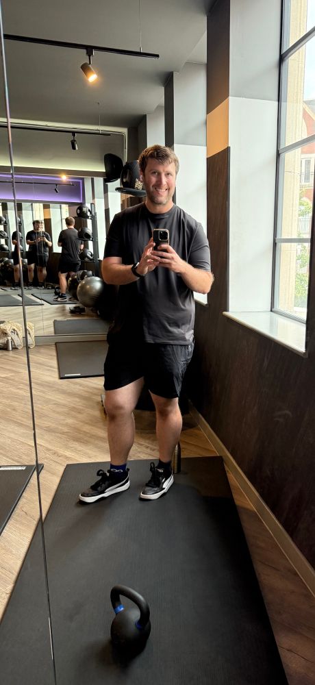 Me in the gym wearing all black t shirt shorts and trainers. 