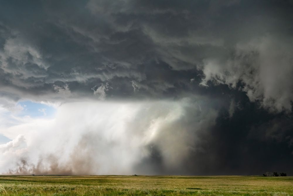 A white cone tornado center frame with clear skies visible through th RFD clear slow and dust also being lofted by said RFD