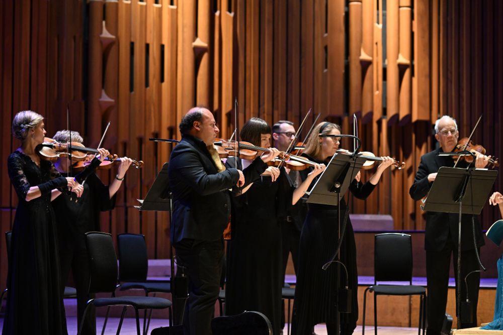 Violinists playing on a stage.