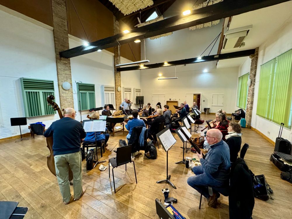Orchestra rehearsing in a large room.