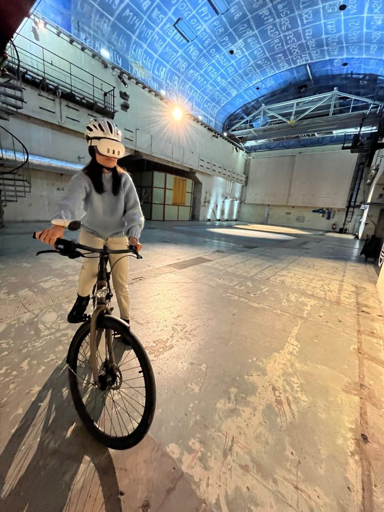 A cyclist riding indoors while wearing a VR headset participates in a trial of CycleARcade, developed at the University of Glasgow's School of Computing Science.