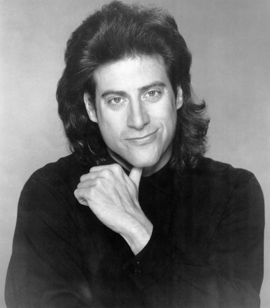 young Richard Lewis headshot, he is smirking with one thumb under his chin