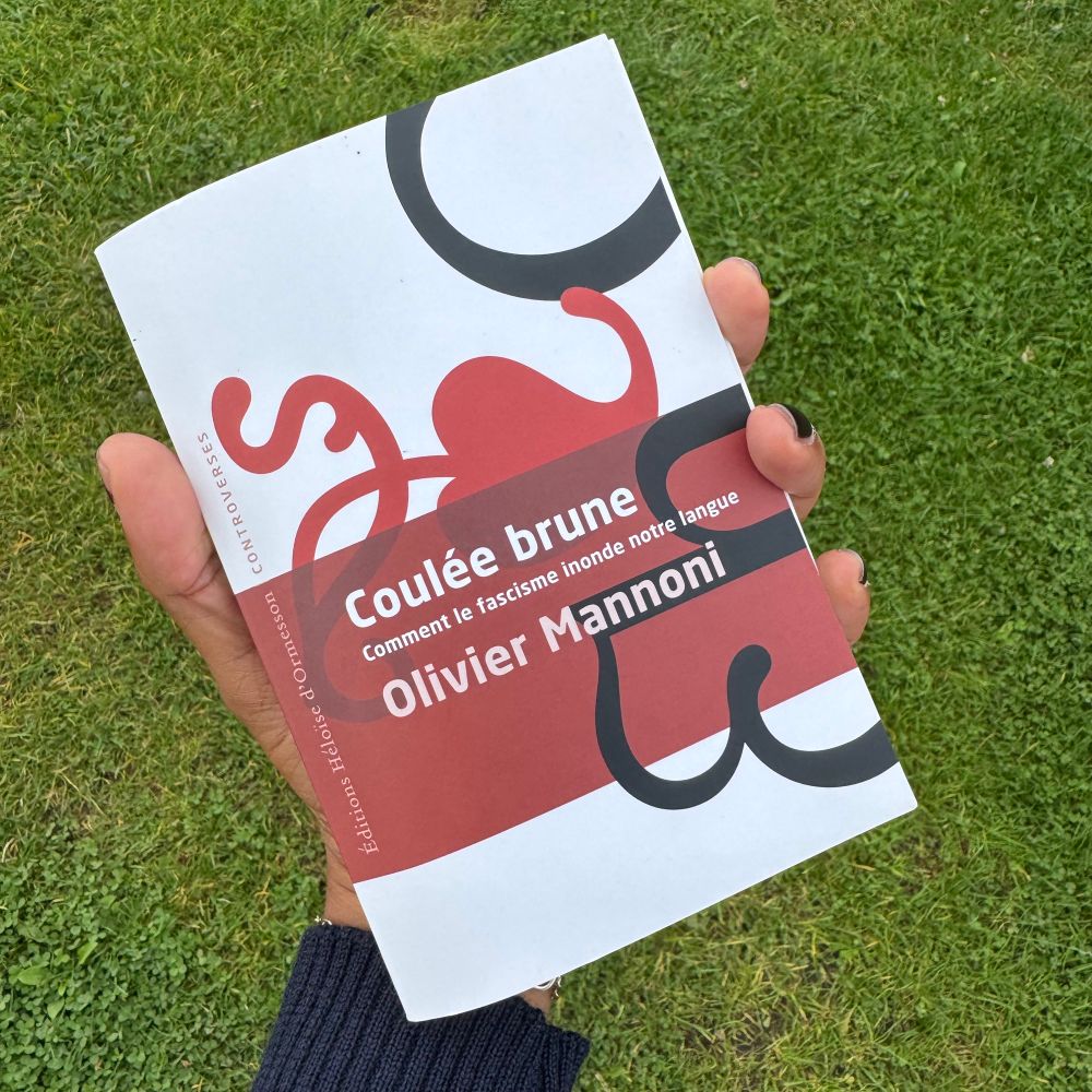 Photo
Sur fond d’herbe verte, ma main tient le livre d’Olivier Mannoni « coulée brune, Comment le fascisme inonde notre langue »