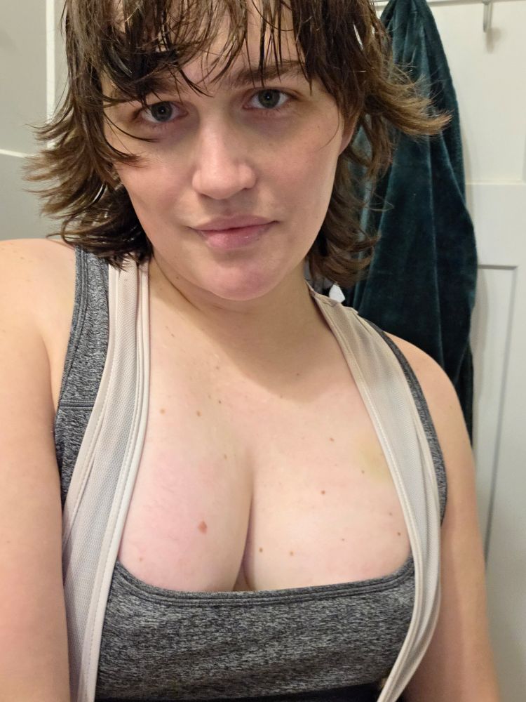me in a sweated-through, gray sports bra overlaid by the white straps of a cycling bib, smiling, looking hot as fuck with tossled, slightly sweaty hair. most importantly, my tits look great 