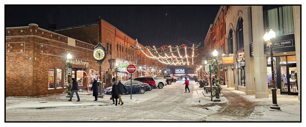 People cross the street at night during winter in downtown Wausau, Wisconsin.
