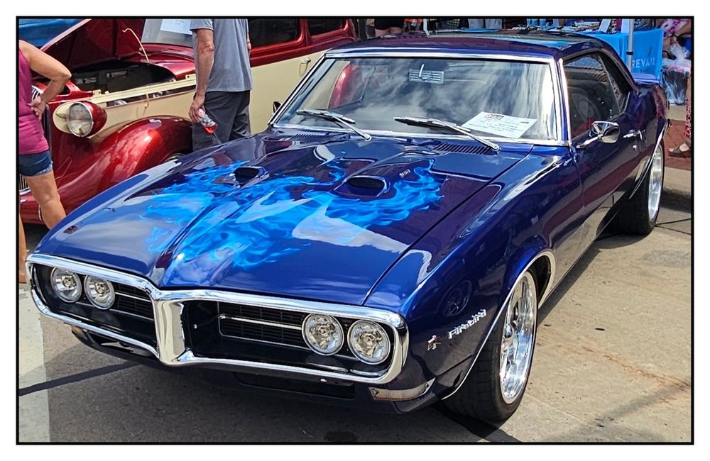 A blue 1968 Pontiac Firebird on display at the 2025 Hub City Car Show in Marshfield, Wisconsin.