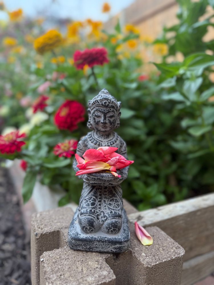 Statue with flower petals in a garden
