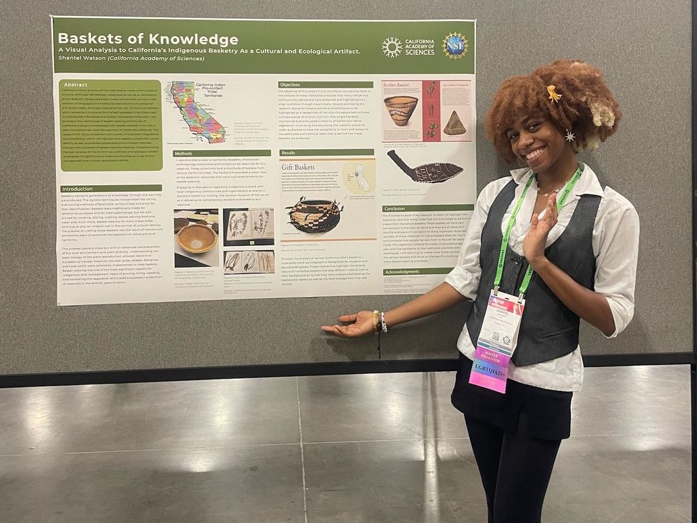 Shantel standing and smiling in front of her scientific poster presentation "baskets of knowledge" 