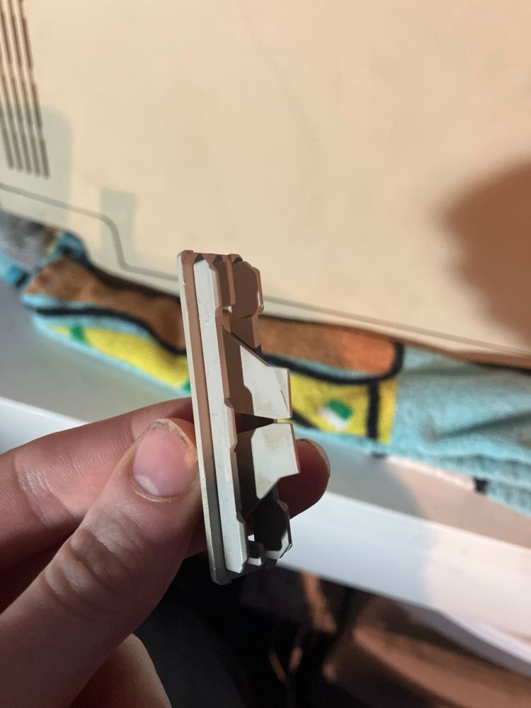 The interrupt and Reset button separated from the Mac. The Mac in the background still face down