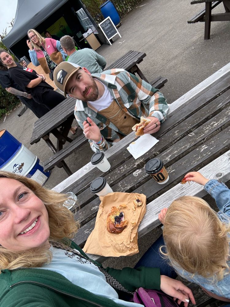 Family having coffee and pastries on a picnic bench
